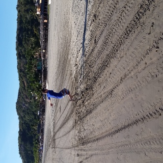 Elliott jumping along the uber-long beach at Stone Island